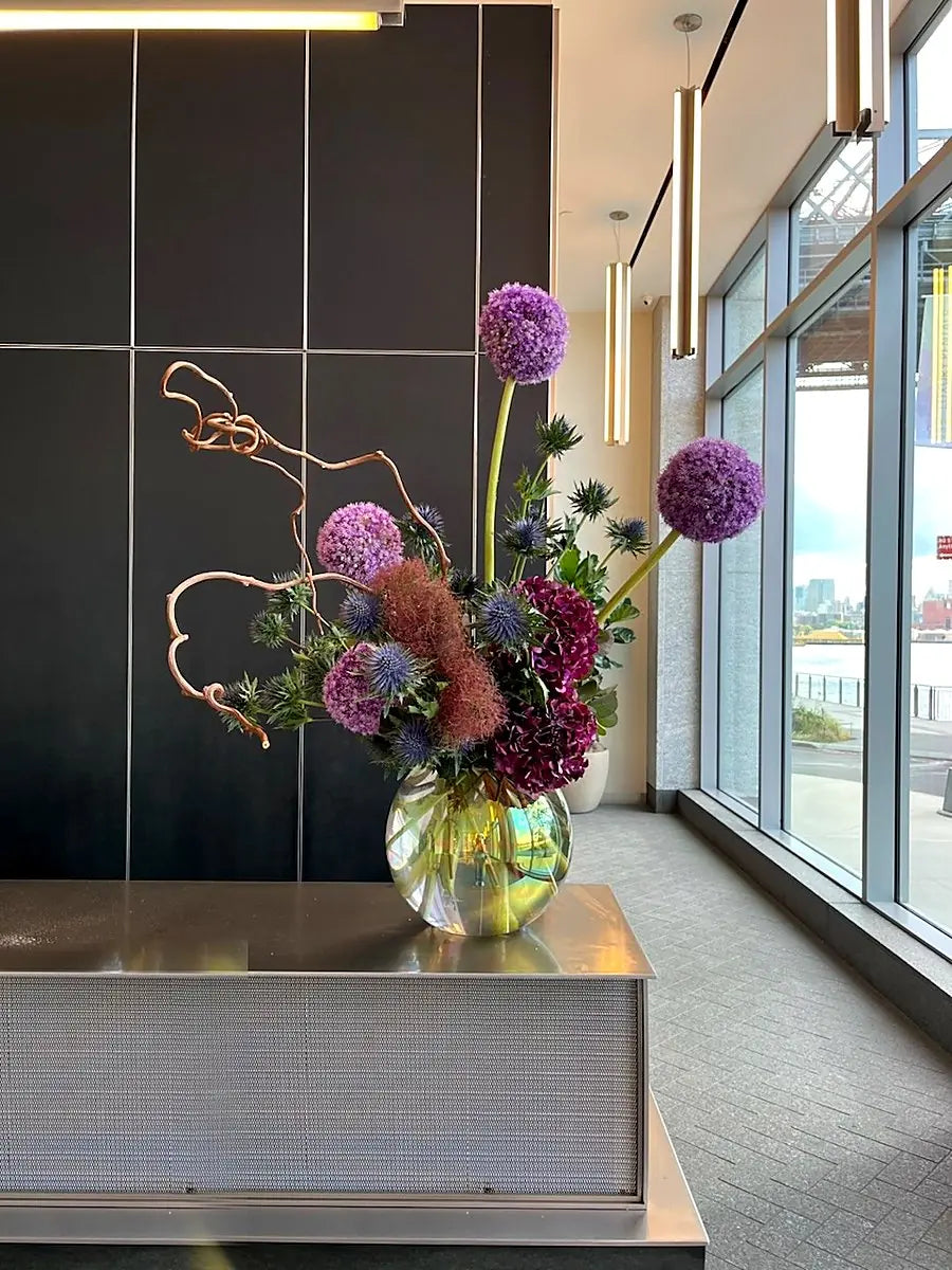 Allium, smoke bush and burgundy hydrangea with a copper branch in a lobby