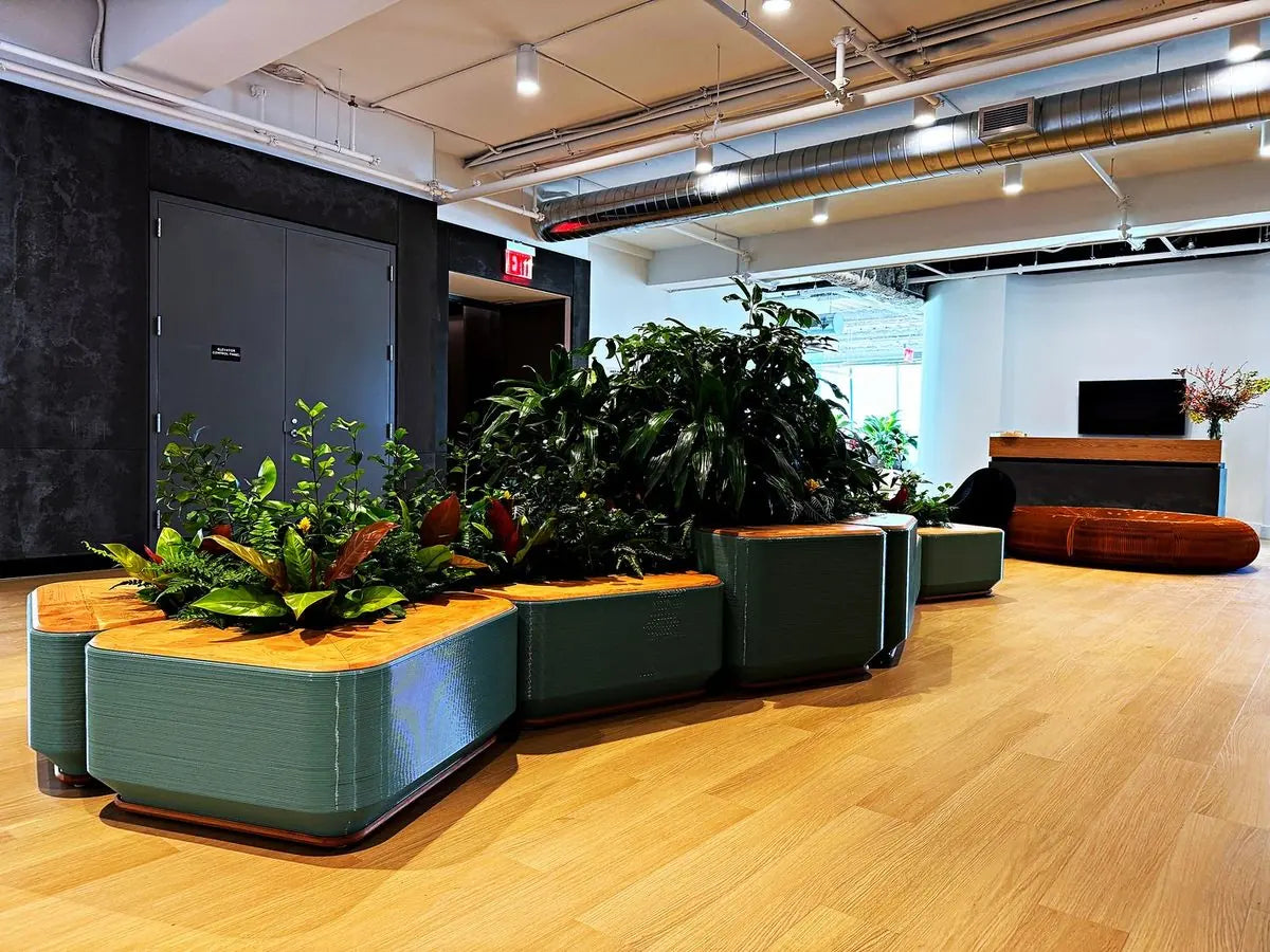 Low planted islands and benches running through a bright open lobby
