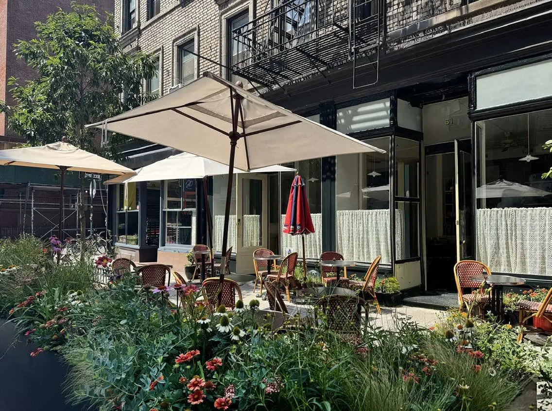 A sidewalk cafe terrace edged with deep borders of echinacea, gaillardia and grasses