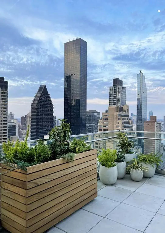 Wooden rooftop planters and sculptural pots overlooking the New York City skyline