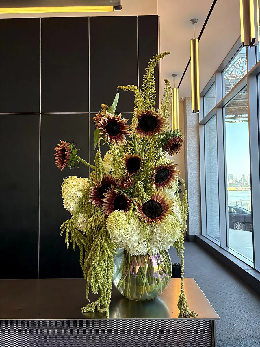 Burgundy sunflowers, white hydrangea and trailing amaranthus in a glass bowl